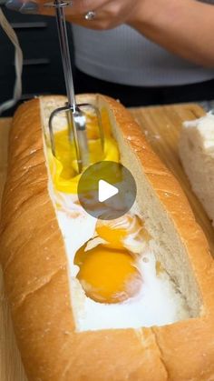 a person cutting eggs in a loaf of bread