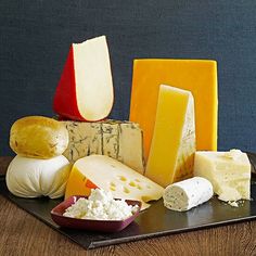 various types of cheese on a black plate