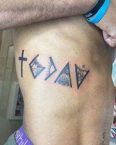 a man with a cross and three triangles tattoo on his stomach, behind him is the word faith