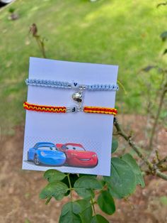 two bracelets with cars on them are attached to a card