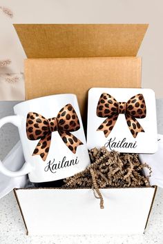 two personalized coffee mugs with bows in a box