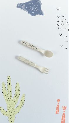 two plastic utensils sitting next to each other on a white surface with cacti in the background