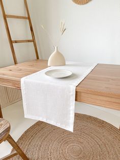 a table with a white plate and vase on it