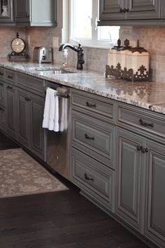 Speckled gray and white granite countertops with gray melburne style cabinets. Dark hardwood floors and dark cabinet hardware. Light Gray Kitchen Cabinets With Dark Granite Countertops, Kitchen With Dark Gray Floors, Gray Cabinets Dark Floors, Grey Cabinets Dark Floors, Dark Floor Grey Cabinets, Gray Cabinets Dark Countertops, Light Gray Cabinets With Dark Countertop, Grey Cabinets With Dark Floors, Cabinets For Dark Floors