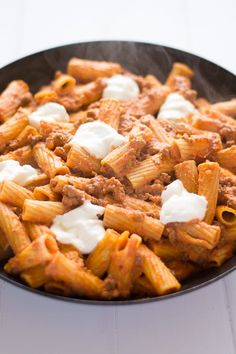 a skillet filled with pasta and cheese