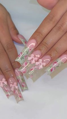 a woman's hands with pink flowers and bows on them, while she has her nails painted