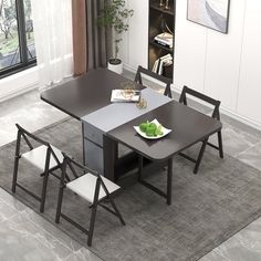 a dining room table with chairs and a bowl of fruit on the plate in front of it