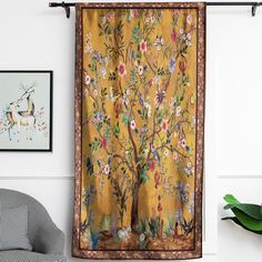 a tapestry hanging on the wall next to a chair and potted plant in front of it