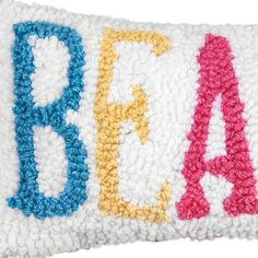 an embroidered pillow with the word bead on it's front and back sides