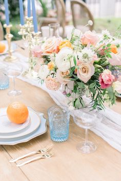 the table is set with flowers and candles