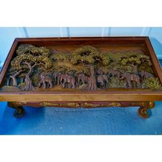 a wooden tray with elephants and trees on it