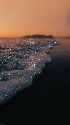 an image of the ocean at night with stars in the sky