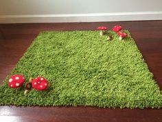 a green rug with red mushrooms on it