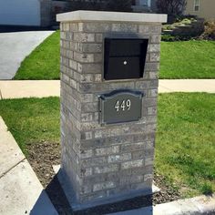 a brick mailbox in front of a house with the number 949 on it