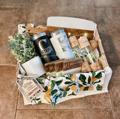 a box filled with lots of different items on top of a tile floor next to a potted plant