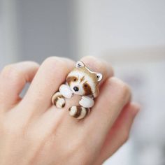 a person wearing a ring with a raccoon on it's finger,