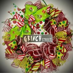 a christmas wreath with green and red bows on it that says grisby street