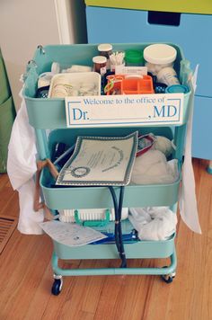 a blue cart with lots of items in it on top of a hard wood floor