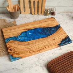 🌟The board color on the list is  Shades Blue 🌟Handmade Olive Wood and Epoxy Serving Board. 🌟Please contact us for bulk and special orders. 🌟If you would like laser engraving personalization, please write in the personalization column. Introducing our exquisitely crafted Personalized Custom Charcuterie Board, a statement piece for any kitchen or dining space. This unique item is perfect for those who appreciate artful, functional decor. ✨ 🌿 Features:  🌟 Personalized just for you 🌟 Stunning epoxy resin art 🌟 Live edge wood beauty 🌟 Ideal for charcuterie, cutting, and serving 💖 Benefits: 🍷 Perfect centerpiece for gatherings and parties 🍰 Versatile - use as a cutting board, cheese board, or serving platter 🎁 Ideal new home gift, birthday gift, or unique present 🚚 Free shipping - Cuterie Board, Blue Charcuterie Board, Rustic Charcuterie Board, Resin Cheese Board, Custom Charcuterie Board, Personalized Board, Art Live, Board Charcuterie, Board Cheese