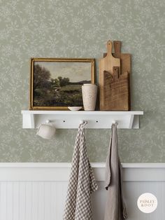 two towels hanging on a shelf next to a painting