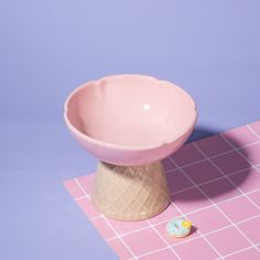 a pink bowl sitting on top of a table next to a rubber ducky toy