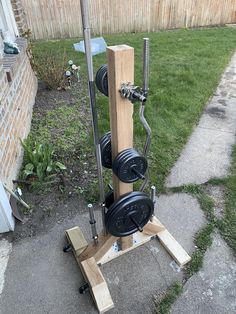 an exercise machine made out of wooden planks in the yard with wheels attached to it