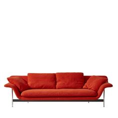 an orange couch with two pillows on it's back and one arm extended to the side