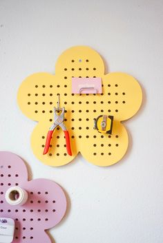 a pair of pliers and some scissors on a peg board with holes in it