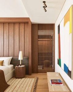 a bedroom with wood paneling and a painting on the wall next to a bed