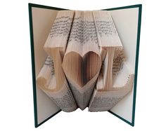 an open book with pages folded in the shape of a heart