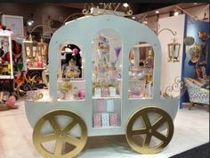 a white and gold carriage with lots of items on it's sides in a store