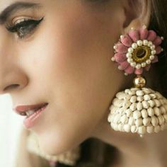 a close up of a person wearing some kind of earring with flowers on it