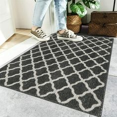 a person standing on top of a brown and white rug next to a potted plant