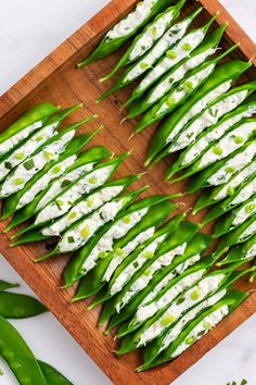 green beans with cream cheese on them are laid out on a cutting board and ready to be eaten