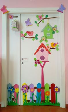 the door is decorated with colorful paper flowers and bird houses, which are hanging on a wire