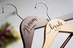 two wooden hangers with the names of bride and groom