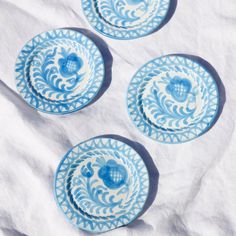 three blue and white plates sitting on top of a table next to eachother