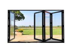 an open folding door in front of a large grassy field with trees and flowers on the other side