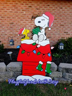 a large snoopy christmas decoration in front of a brick building