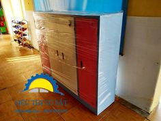 a cardboard box sitting on top of a wooden floor next to a blue and white wall