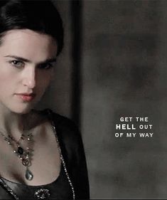 a woman wearing a black top and necklace with words on the side that read, get the hell out of my way