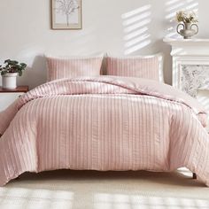 a bed with pink comforter and pillows in a room