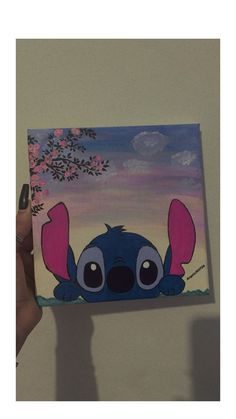 someone holding up a painting of stitchy from the disney movie, lilpui