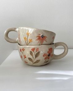 two white bowls with orange and yellow flowers on them