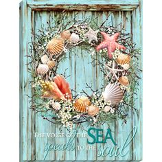 a wreath with seashells and starfish is hanging on a blue wooden door