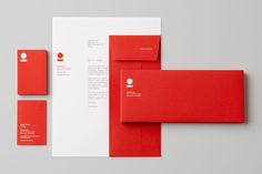 red and white stationery with envelopes, business card and letterhead on grey background