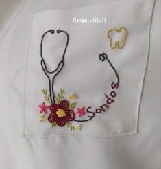 a white shirt with a flower and a stethoscope embroidered on the chest