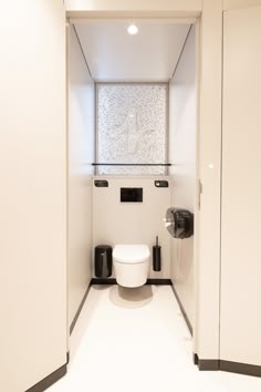 a white toilet sitting inside of a bathroom next to a window