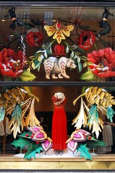 an elaborate display case in a store window decorated with paper flowers and other decorative items