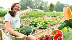 a woman sitting in a garden filled with lots of fruits and veggies next to vegetables